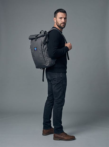Grey roll-top backpack, full-length side view — AI-generated product photo, same male model, frame 2 of 25