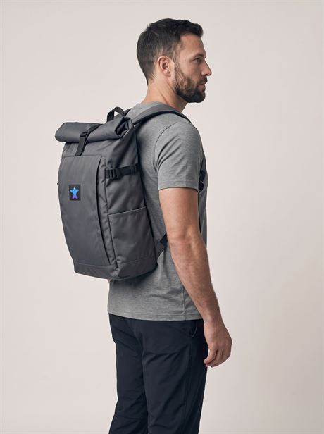 Grey roll-top backpack over a grey T-shirt, side view — AI-generated product photo, same male model, frame 13 of 25